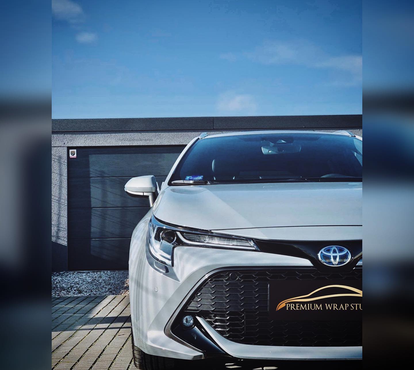 Auto z oznaczeniem Premium Wrap Studio przed studiem
